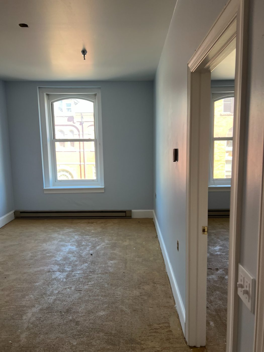 Light blue bedroom with freshly painted doorway and window trim