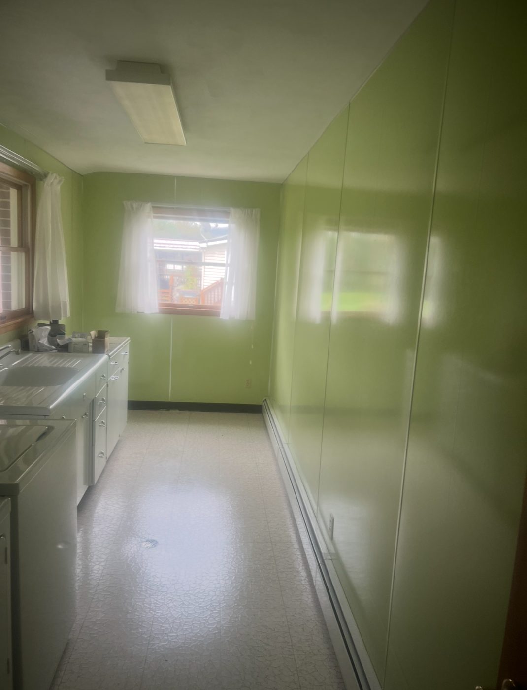 Before: dated laundry room with worn green walls
